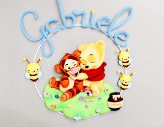 Fiocco nascita a tema Winnie The Pooh con nome Gabriele in tricotin